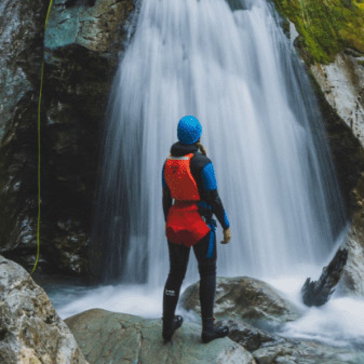 a man standing next to a waterfall